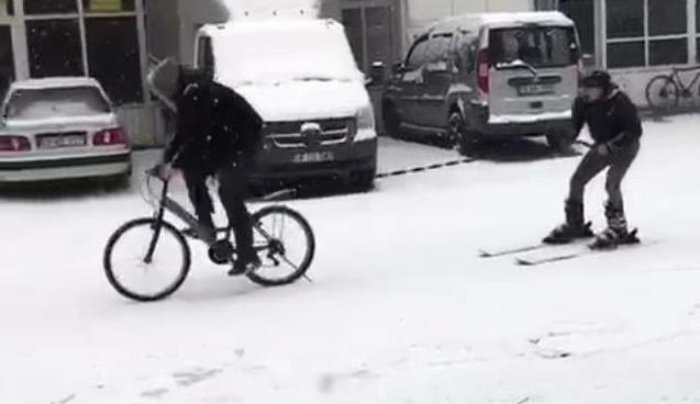 Karla kaplanan yolda kayak takımları ile kayak yaptı